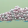 Цифровое изображение спортивной обуви, сделанной из розовых и белых сфер на зелёном фоне.
