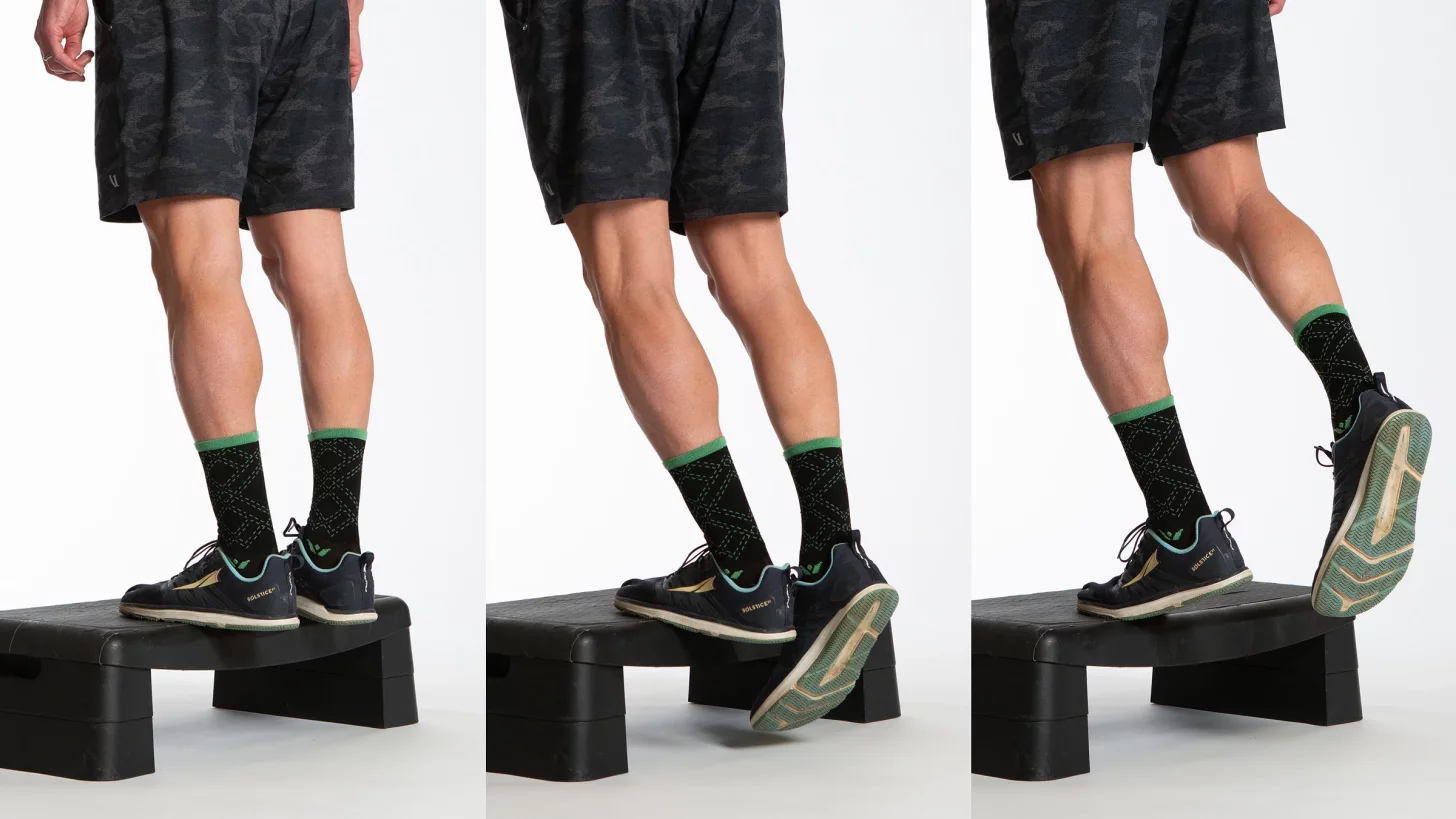 Фитнес-модель выполняет подъемы на носки на одной ноге Фитнес-модель выполняет подъемы на носки на одной ноге