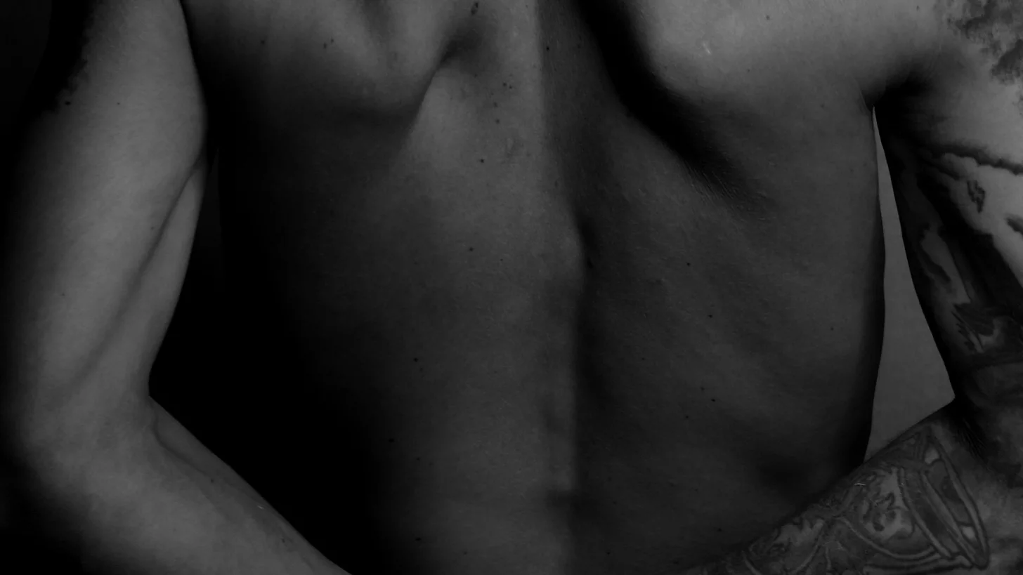 Черно-белое фото нижней части спины мужчины с татуировками Черно-белое фото нижней части спины мужчины с татуировками