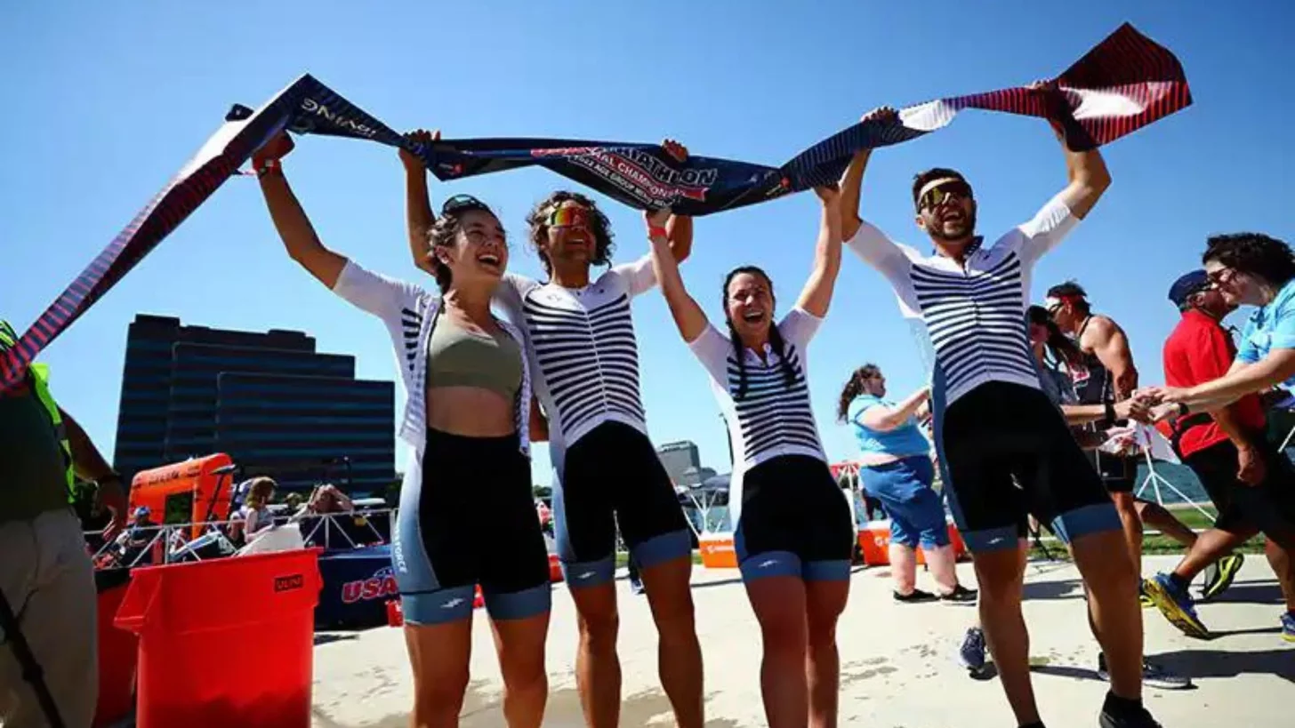 После того как команда выяснила, какая дистанция в триатлоне смешанной эстафеты, они празднуют свою победу.