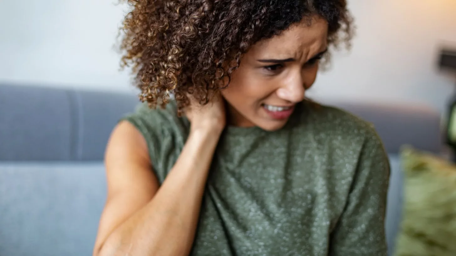 Женщина массирует свои больные мышцы