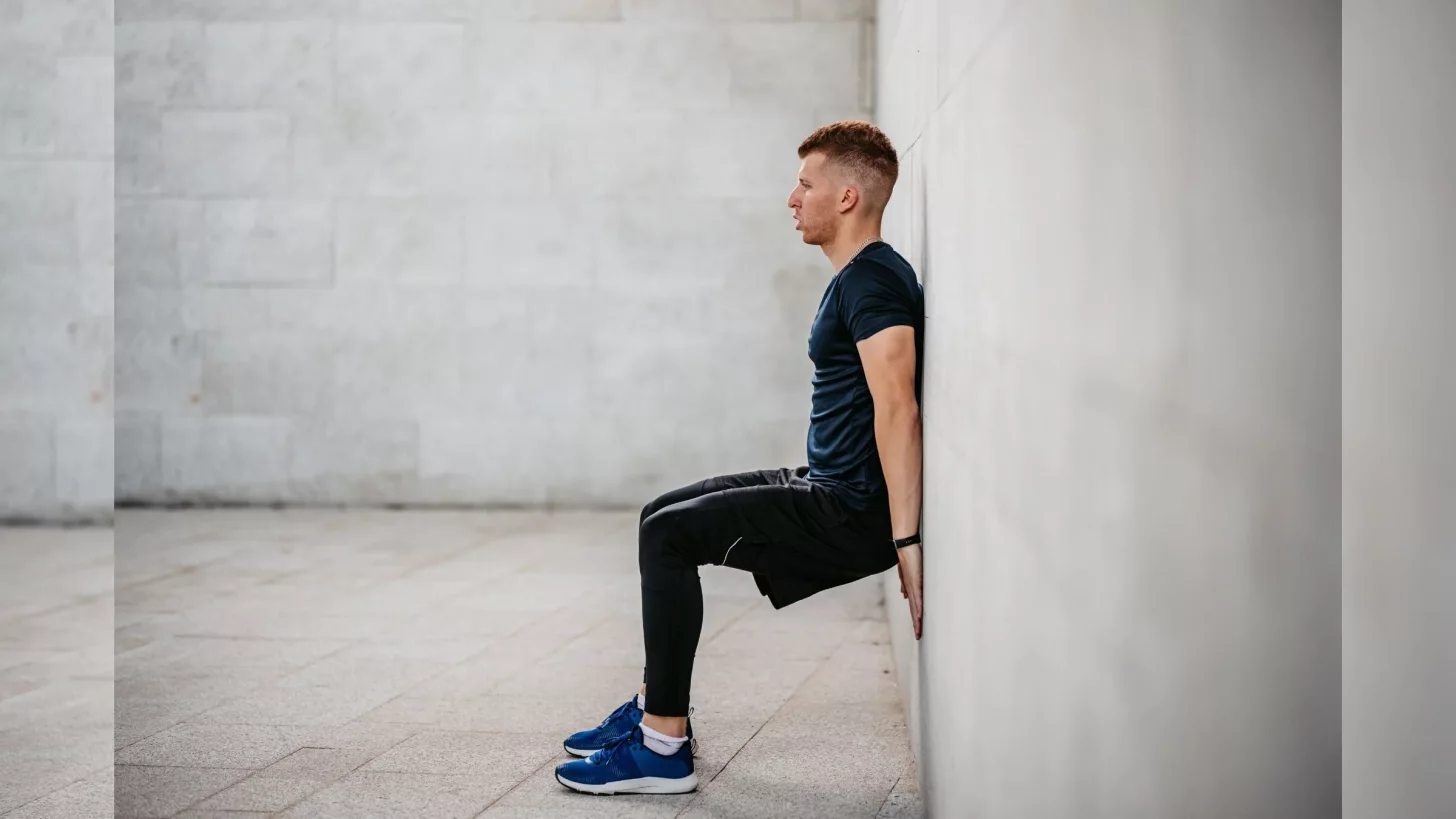 Триатлонист выполняет упражнение с коленями над пальцами ног