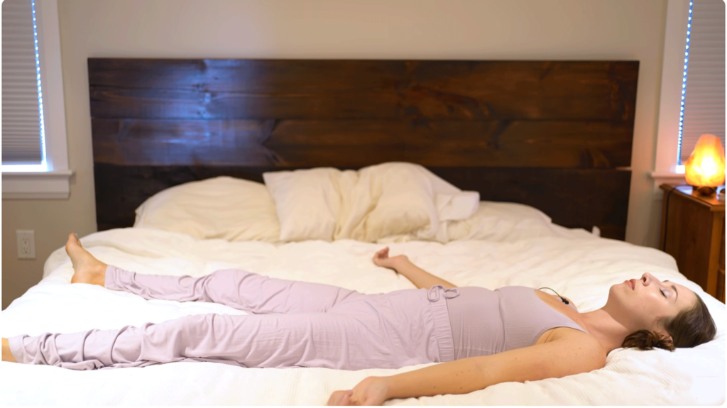 Йога с Кассандрой, лежащей на спине в постели Йога с Кассандрой, лежащей на спине в постели